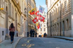 Un suggestivo scorcio panoramico di Rue de l'Hotel-de-Ville, nella vecchia città di Ginevra, con bandiere e gente in strada - © Michal Ludwiczak / Shutterstock.com 
 ...