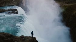 Un turista contempla la potenza della Cascata Gulfoss in Islanda