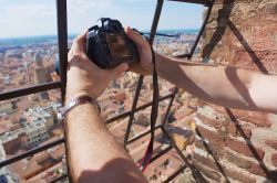 Un turista scatta una fotografia dalla cima della Torre degli Asinelli a Bologna, Emilia-Romagna - © Dmitry Chulov / Shutterstock.com