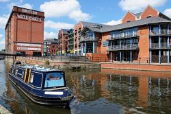 Una barca naviga lungo il Nottingham e Beeston Canal, Inghilterrra. Sullo sfondo, edifici affacciati sul molo cittadino - © Caron Badkin / Shutterstock.com