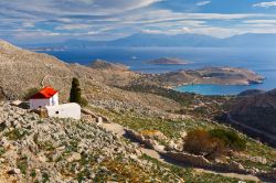 Una chiesa con il tetto rosso sulle colline dell'isola di Chalki, Dodecaneso, Grecia.

