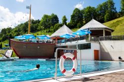 Una donna nuota nella piscina vicino alla Schattberg X-press cable car station a Saalbach (Austria) - © josefkubes / Shutterstock.com