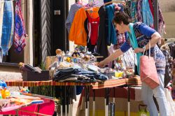 Una donna sceglie degli abiti in un mercato locale di Coburgo, Germania - © TIvanova / Shutterstock.com