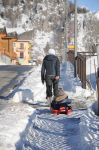 Una giovane mamma con il suo bimbo sullo slittino nelle strade di Valpelline, Valle d'Aosta.

