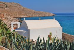 Una piccola cappella affacciata sul lungomare vicino a Pondomos Beach, Chalki, Grecia.

