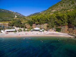 Una spiaggia dell'isola di Vis, Croazia, con turisti in relax. La natura ancora selvaggia e il mare dalle mille tonalità del blu e dell'azzurro ne fanno una delle destinazioni ...