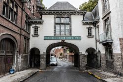 Una stradina medievale con porta d'ingresso alla città di Tournai, Belgio. Oggi qui si trova il museo del folklore - © Werner Lerooy / Shutterstock.com