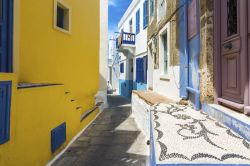 Una tipica viuzza del villaggio di Mandraki a Nisyros, Grecia. Le case che si affacciano sul centro storico sono caratterizzate da dettagli dipinti con colori pastello.

