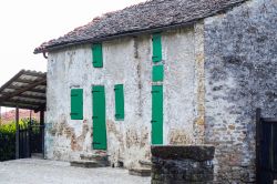 Una vecchia casa in pietra con infissi in legno verde a Murazzano, Langhe, Piemonte.
