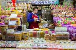 Una venditrice di caramelle controlla i suoi prodotti in un negozio di Chiufen, Taiwan - © Chalermpon Poungpeth / Shutterstock.com