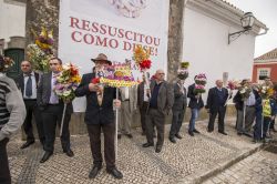 Gli uomini del paese trasportano le candele con decorazioni floreali lungo il percorso della processione per la resurrezione di Cristo a Sao Bras de Alportel, Portogallo - © Mauro Rodrigues ...