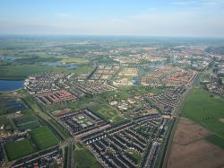Veduta dal parapendio del canale di Zwolle e della regione di Overijssel (Olanda) con campi verdi in una giornata dal cielo azzurro.



