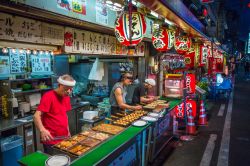 Venditori di strada a Osaka preparano Takoyaki, Giappone: si tratta di tipiche polpette fritte di forma sferica fatte di polpo e pastella - © MACH Photos / Shutterstock.com