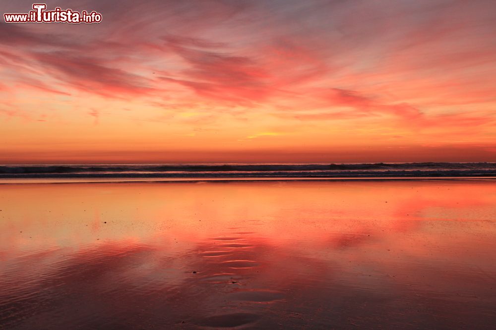 Immagine Riflessi sul mare al tramonto nella città di Costa da Caparica, Portogallo. Qui si trova la più estesa spiaggia del Portogallo: ben 13 chilometri di lunghezza.