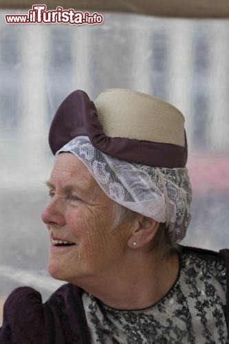 Immagine Ritratto di donna al mercato tradizionale di Alkmaar (Olanda) - Soprattutto le donne di una certa età, in Olanda e in particolar modo a Alkmaar, non hanno mai rinunciato alla tradizione di costume che da sempre prevede un decoro altissimo nello stile. Ne è la testimonianza questa immagine dove una donna indossa il classico cappello che in antichità serviva per distinguere il ceto nobile - © Michela Garosi / www.thetravelover.com/it/