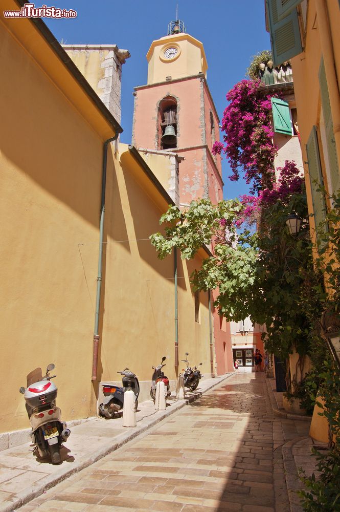 Immagine Scooters parcheggiati in un vicoletto di Saint-Tropez, Francia. Sullo sfondo, la torre campanaria di una chiesa.