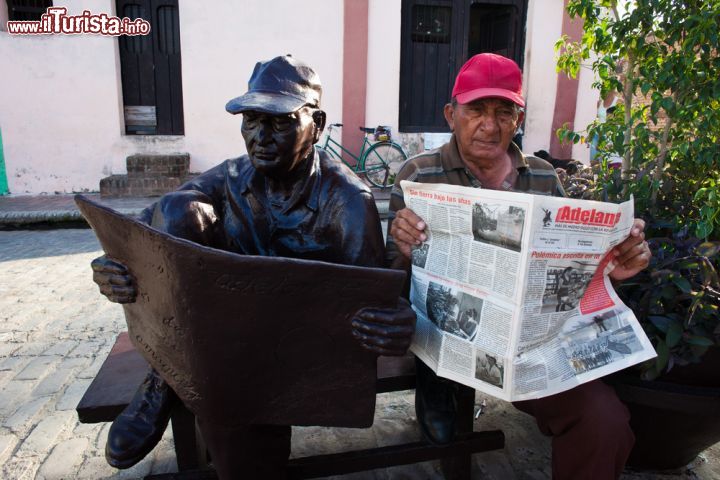 Immagine Scultura a Camaguey, Cuba - Un abitante cubano posa per una simpatica fotografia vicino ad una scultura che lo ritrae. Le vie della città ospitano molte opere scultoree di persone sconosciute © Martchan / Shutterstock.com