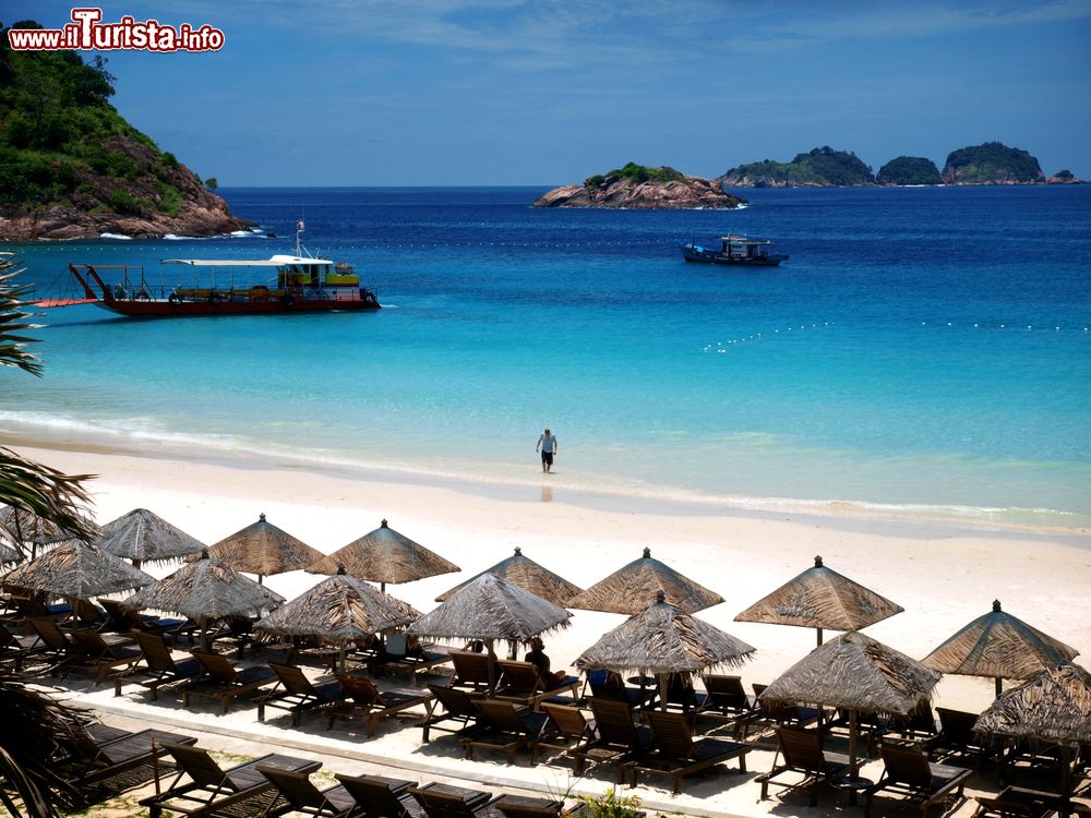 Immagine Sdraio e ombrelloni di paglia su una spiaggia a Redang, Malesia. L'isola offre diverse strutture ricettive fra cui scegliere per trascorrere una vacanza all'insegna del relax e delle attività acqatiche.