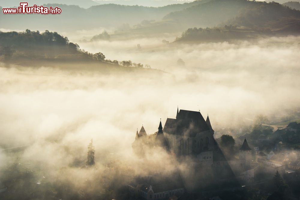 Immagine Il villaggio di Biertan fotografato di mattina con la nebbia, Transilvania, Romania. Biertan sorge in una zona collinare, sulla riva sinistra della Grande Tarnava, fiume che scorre per 221 km.