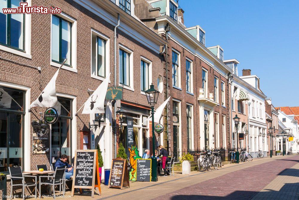 Immagine Un locale con tavolini all'esterno in Cattenhagestraat Street, nella città vecchia di Naarden, Paesi Bassi - © TasfotoNL / Shutterstock.com