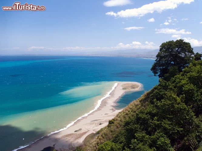 Immagine Scorcio che mostra la barra di sabbia sul mare di Tindari (Sicilia) - Sembra lo sbaglio di un pittore che, intento a dipingere una vista panoramica del mar tirreno, ha lasciato che un pennello si prendesse la libertà di scivolarci all'interno, forse invogliato dalla splendida acqua per farsi un bagno. In realtà si tratta di un'arena dalla forma allungata da cui si possono ammirare gli stupendi laghetti di Marinello. L'insieme regala un'esplosione di natura selvaggia e non educata, bensì quasi anarchica nella sua disposizione sfacciata che agli occhi del visitatore, non può che destare uno stupore senza pari - © Oskar Orsag / Shutterstock.com