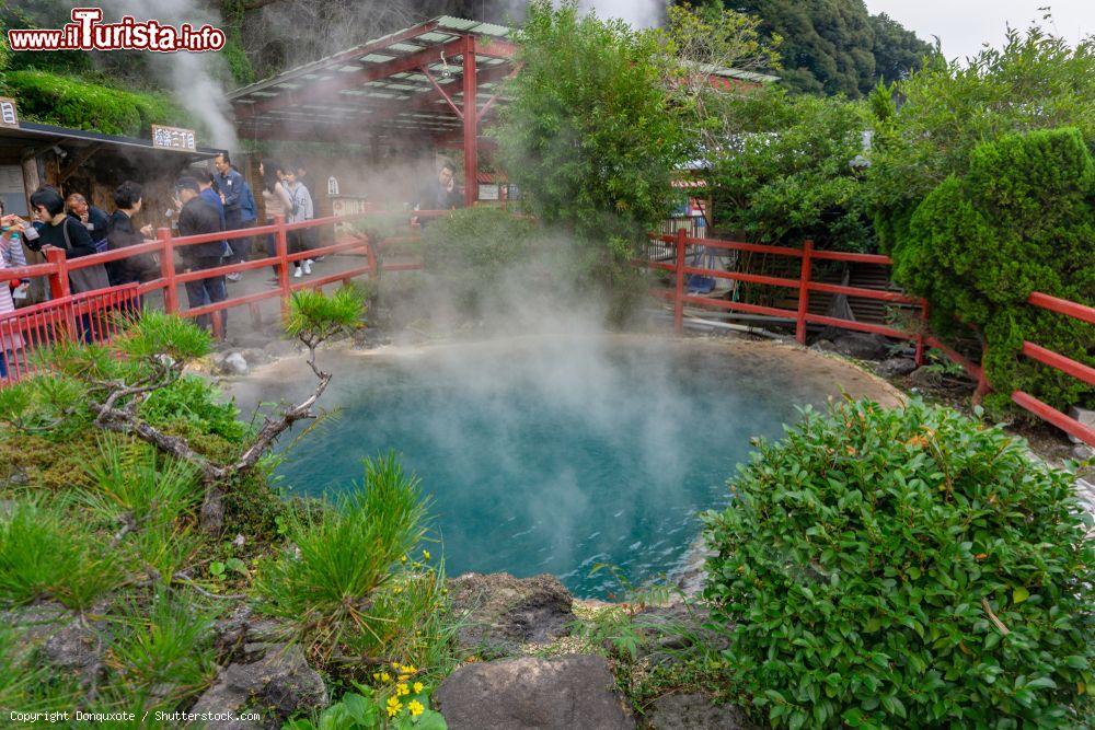 Immagine La sorgente Kamado Jigoku Pond a Beppu, Oita, Giappone, in autunno. Simbolo di questo laghetto di acqua bollente è un demone rosso brillante su un'enorme pentola da cucina - © Donquxote / Shutterstock.com