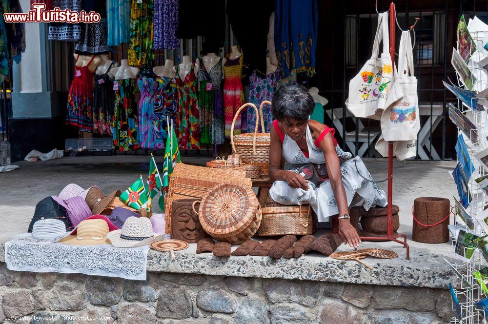 Immagine Una venditrice di souvenir nella principale via lungo il porto di Roseau, Dominica. Qui è un tripudio di colori, oggetti di artigianato locale e profumi di frutta ed erbe aromatiche - © byvalet / Shutterstock.com