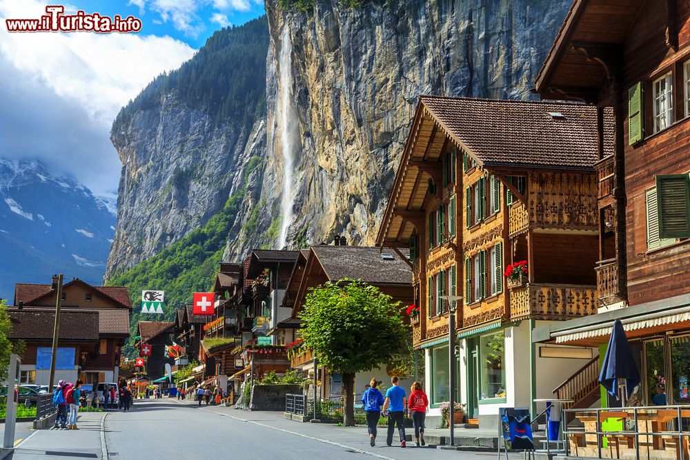 Immagine Veduta della principale strada di Lauterbrunnen, Canton Berna, Svizzera, con negozi e hotels. Sullo sfondo, la cascata Staubbach che con il suo salto di quasi 300 metri è la terza più alta del paese.