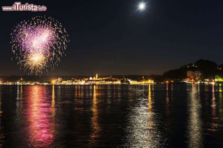 Immagine Lo spettacolo dei fuochi d'artificio sul lago Maggiore ad Arona, Piemonte - Una bella immagine di giochi pirotecnici che illuminano le acque del lago © Massimo De Candido / Shutterstock.com