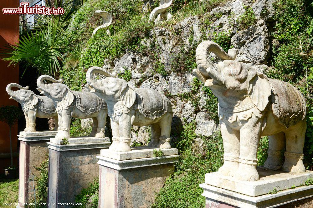 Immagine Statue di elefanti allo Scherrer Park di Morcote, Svizzera. Sul muro ricoperto di vegetazione sono incastonate raffigurazioni di serpenti e di mucche - © Stefano Ember / Shutterstock.com