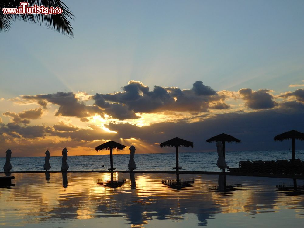 Immagine Una suggestiva alba fotografata a Freeport, Grand Bahama, Arcipelago delle Bahamas. I colori del cielo si riflettono sulle acque dell'immensa piscina di un resort costruito lungomare.