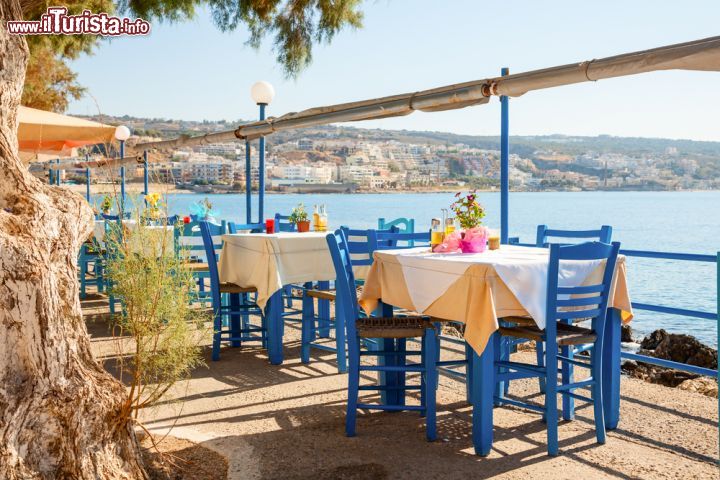 Immagine Taverna con vista mare a Heraklion, Creta - I tavolini di una caratteristica taverna che si affaccia sul lungomare di Heraklion: qui si possono assaporare le specialità gastronomiche dell'isola fra cui miele, formaggi e ogni genere di pesce © Dmitry Naumov / Shutterstock.com