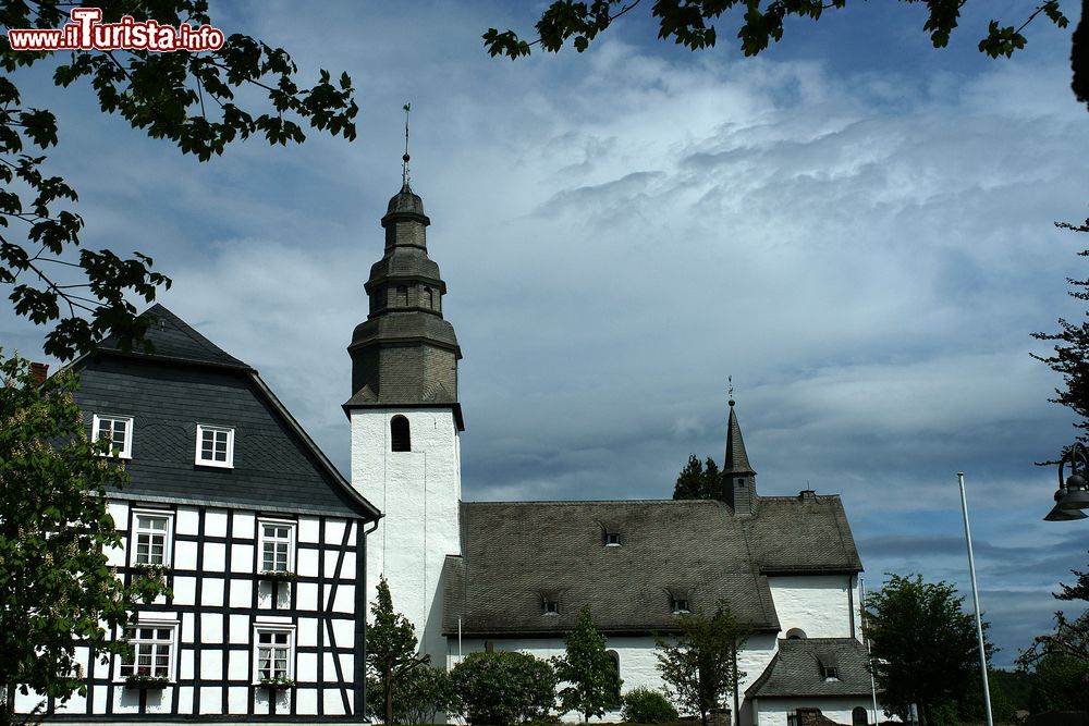 Immagine Una tipica casa con travi in legno nella cittadina di Winterberg, Germania, con a fianco la chiesa.