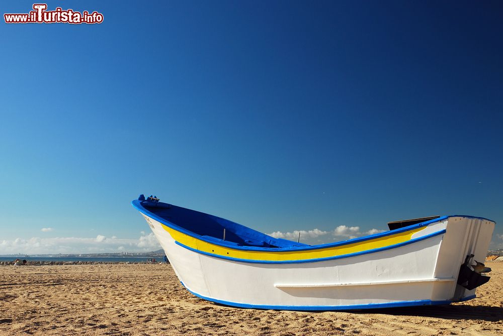 Immagine Una tradizionale barca da pesca sulla spiaggia vuota di Costa da Caparica, Portogallo.