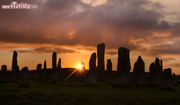 Immagine Pietre megalitiche a Lewis and Harris, Scozia - Un tramonto dall'intenso color arancione avvolge i suggestivi megaliti che si innalzano in quest'isola delle Ebridi Esterne. Collegate fra di loro da una stretta lingua di terra, Lewis and Harris, che a dispetto del nome sono però un'unica isola divisa in due parti, hanno saputo mantenere intatte le loro tradizioni e le usanze di epoca gaelica © Anneka / Shutterstock.com