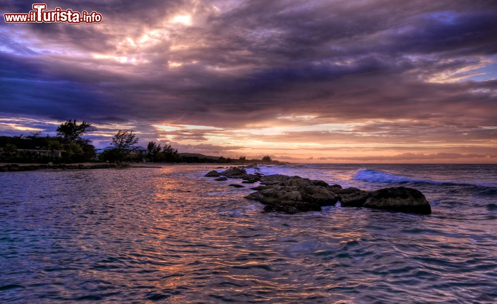 Immagine Tramonto sul mare a Runaway Bay, Giamaica. Gli splendidi colori del cielo si riflettono sulle acque del mare caraibico e sulle rocce che affiorano in superficie.