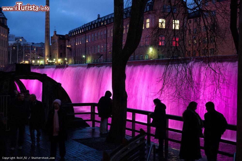 Immagine Turisti ammirano il paesaggio illuminato di Norrkoping, Svezia. Luci colorate abbelliscono la città durante il periodo natalizio - © Rolf_52 / Shutterstock.com