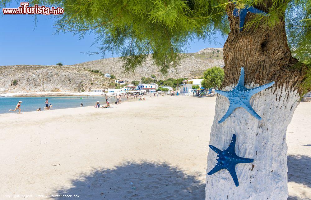 Immagine Turisti in relax su una spiaggia dell'isola di Pserimos, Dodecaneso (Grecia) - © Nejdet Duzen / Shutterstock.com