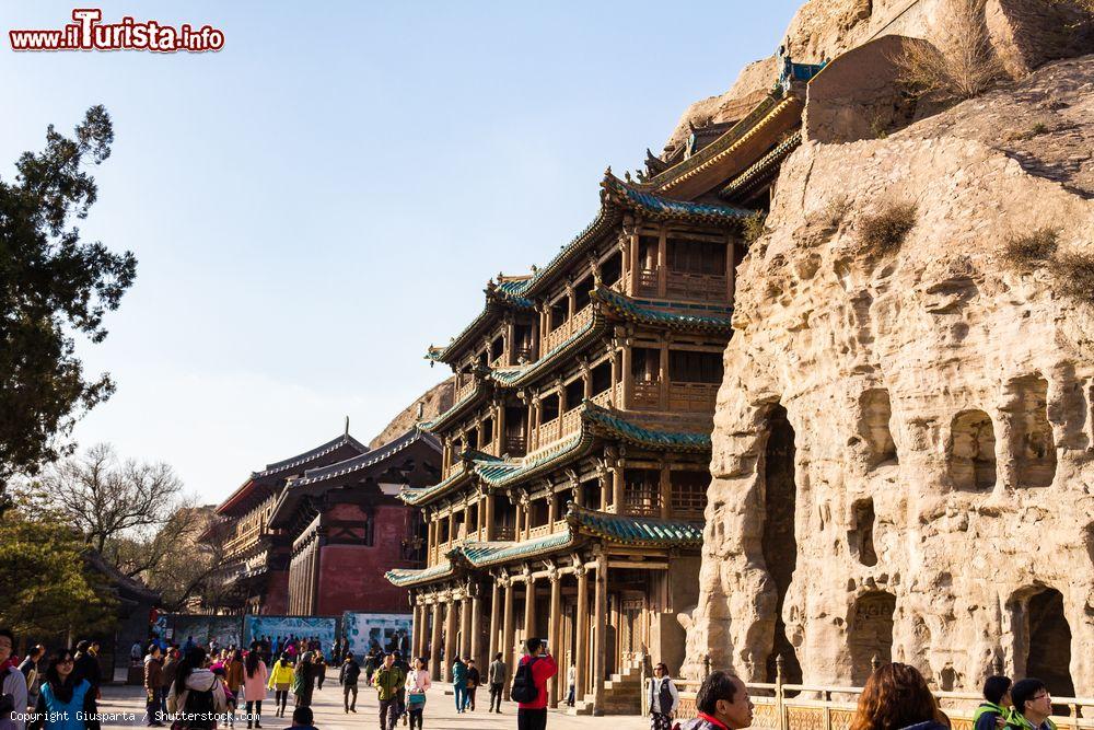 Immagine Turisti in visita alle Yungang Grottoes di Datong, Cina. Sito Unesco, accoglie alcune delle statue buddhiste più belle di tutta la Cina - © Giusparta / Shutterstock.com