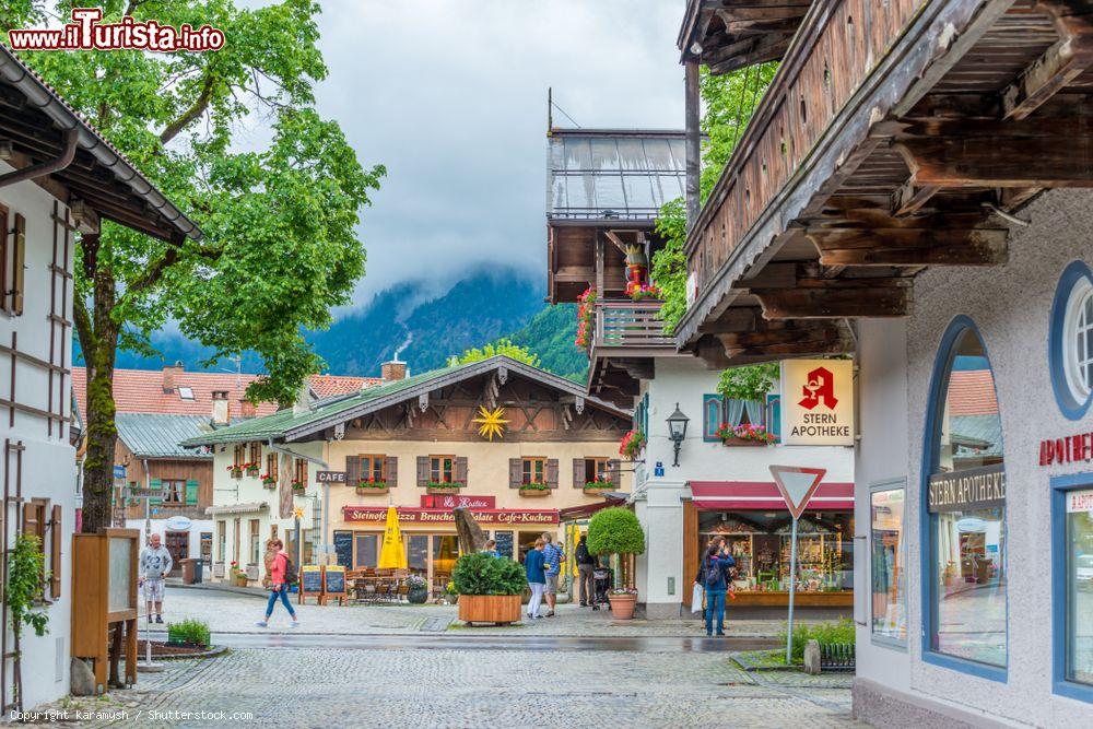 Immagine Turisti in visita nel centro storico di Oberammergau, Baviera, Germania: questa cittadina è famosa per i numerosi dipinti che decorano le facciate delle case - © karamysh / Shutterstock.com