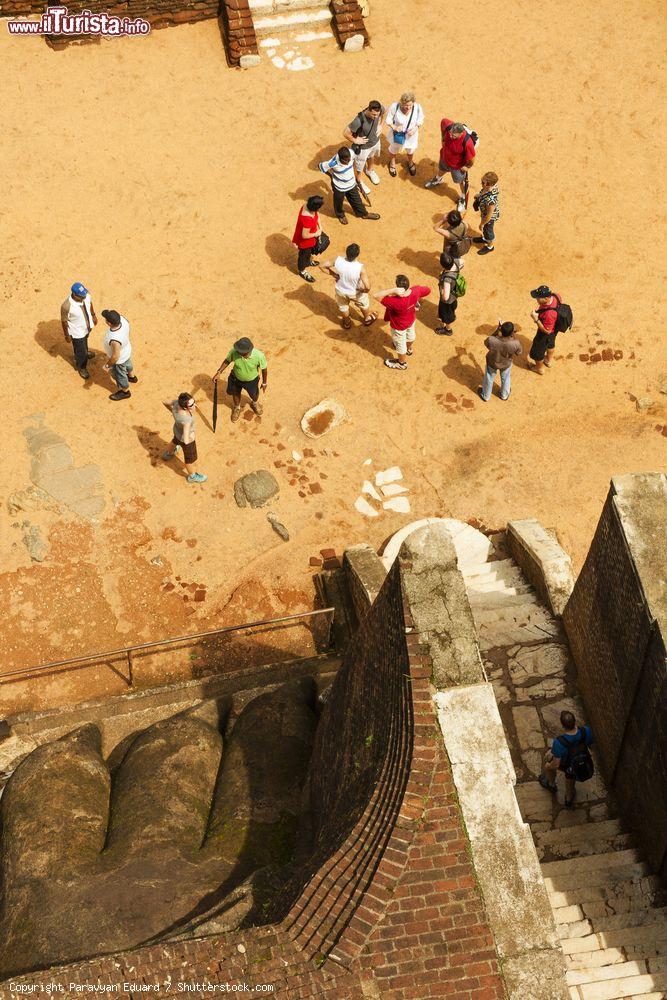 Immagine Turisti visti dall'alto della Lion Rock (Sri Lanka). Accanto a loro si nota la grande zampa di leone scolpita nella roccia - © Paravyan Eduard / Shutterstock.com