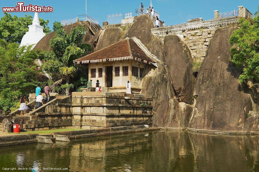 Immagine Turisti nel tempio di roccia di Isurumuniya nei pressi di Anuradhapura, Sri Lanka. Questo suggestivo tempio di roccia è incastonato attorno a un laghetto di loto: salendo in cima alla parete rocciosa si può ammirare dall'alto lo stupa a forma di campana e un paio di impronte del Buddha - © Dmitry Chulov / Shutterstock.com