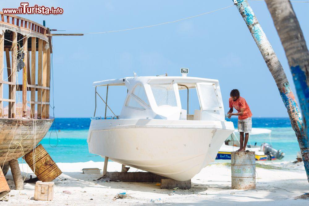 Immagine Un artigiano ripara un'imbarcazione per la nuova stagione turistica a Maafushi, Maldive - © Vitaly Khodyrev / Shutterstock.com
