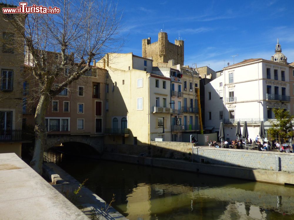 Immagine Un canale della città di Narbonne, Francia. Sullo sfondo, un ristorante con tavolini all'aperto.