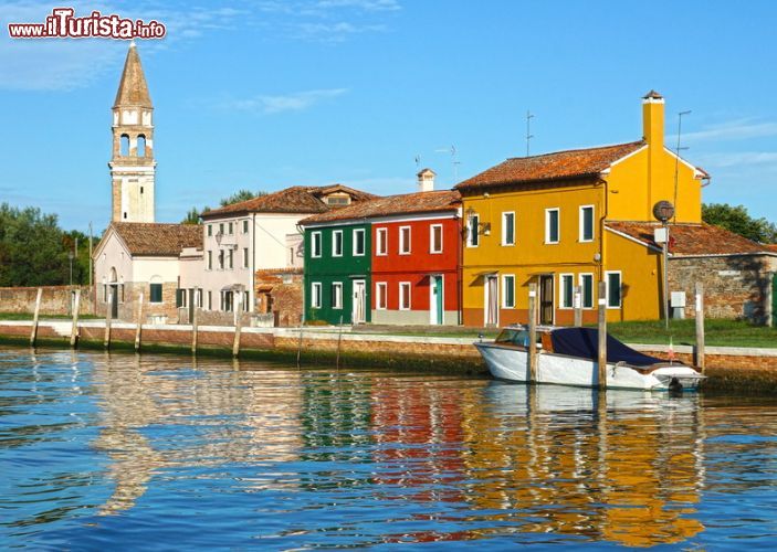 Immagine Un imbarcadero di Burano, con veduta della Chiesa di San Martino - la Chiesa di San Martino è l'unico edificio religioso della piccola isola di Burano. Costruita nel 1500, questa chiesa è diventata ormai un simbolo di Burano, in particolare grazie al suo famoso campanile. - © dimbar76 / Shutterstock.com