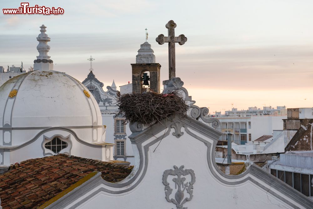 Immagine Un nido di cicogne e le torri della principale chiesa di Olhao, Portogallo.