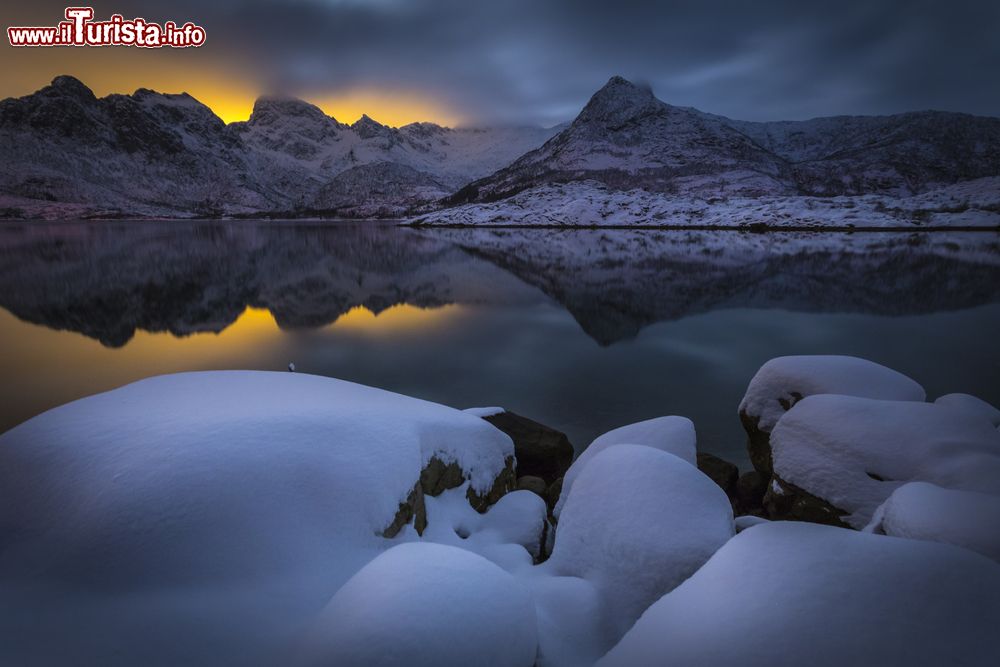 Immagine Un pittoresco paesaggio invernale a Svolvaer, Lofoten, Norvegia, con i colori del tramonto riflessi nell'acqua.