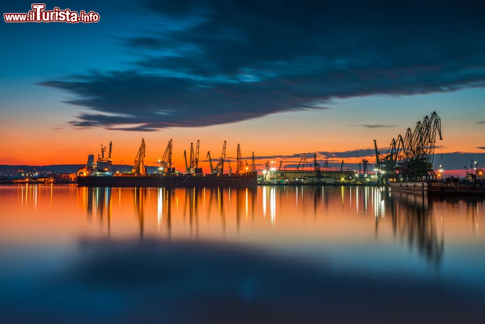 Immagine Un suggestivo tramonto colorato sul porto e sulle gru industriali a Varna, Bulgaria.