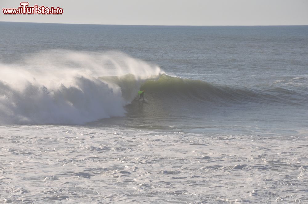 Immagine Un surfista impegnato a cavalcare un'onda a Nazaré, Portogallo.