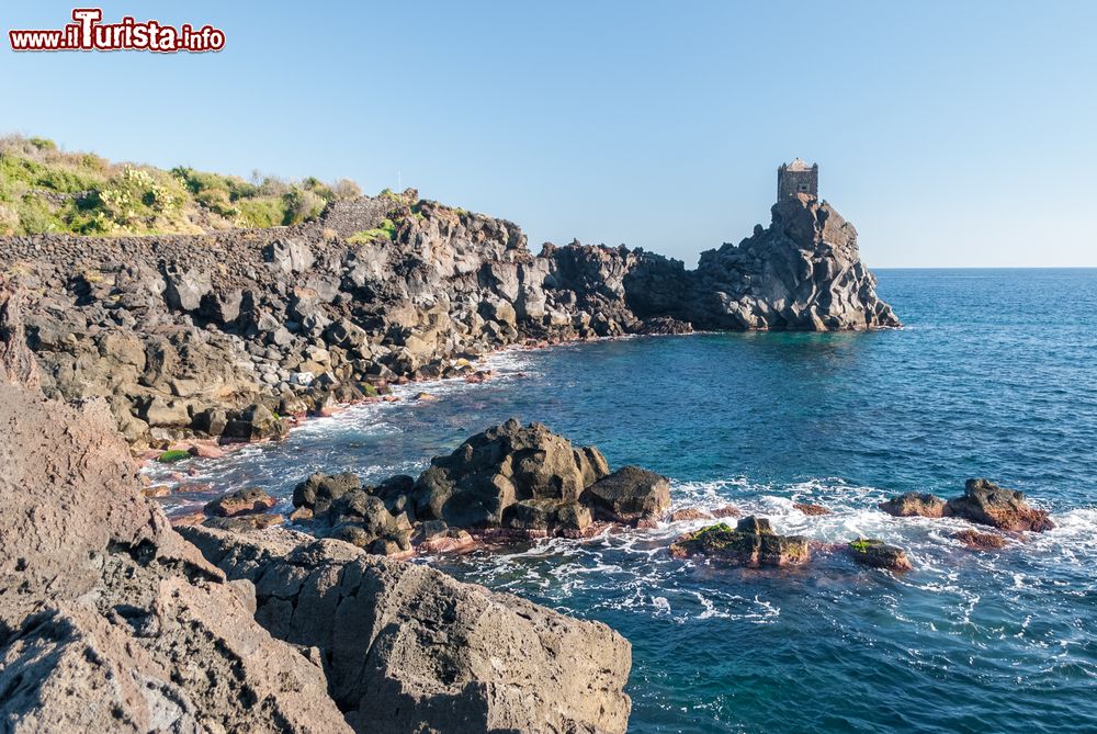 Immagine Un tratto di costa rocciosa della scogliera vicino a Acireale, Sicilia. Sullo sfondo, una torre di guardia.